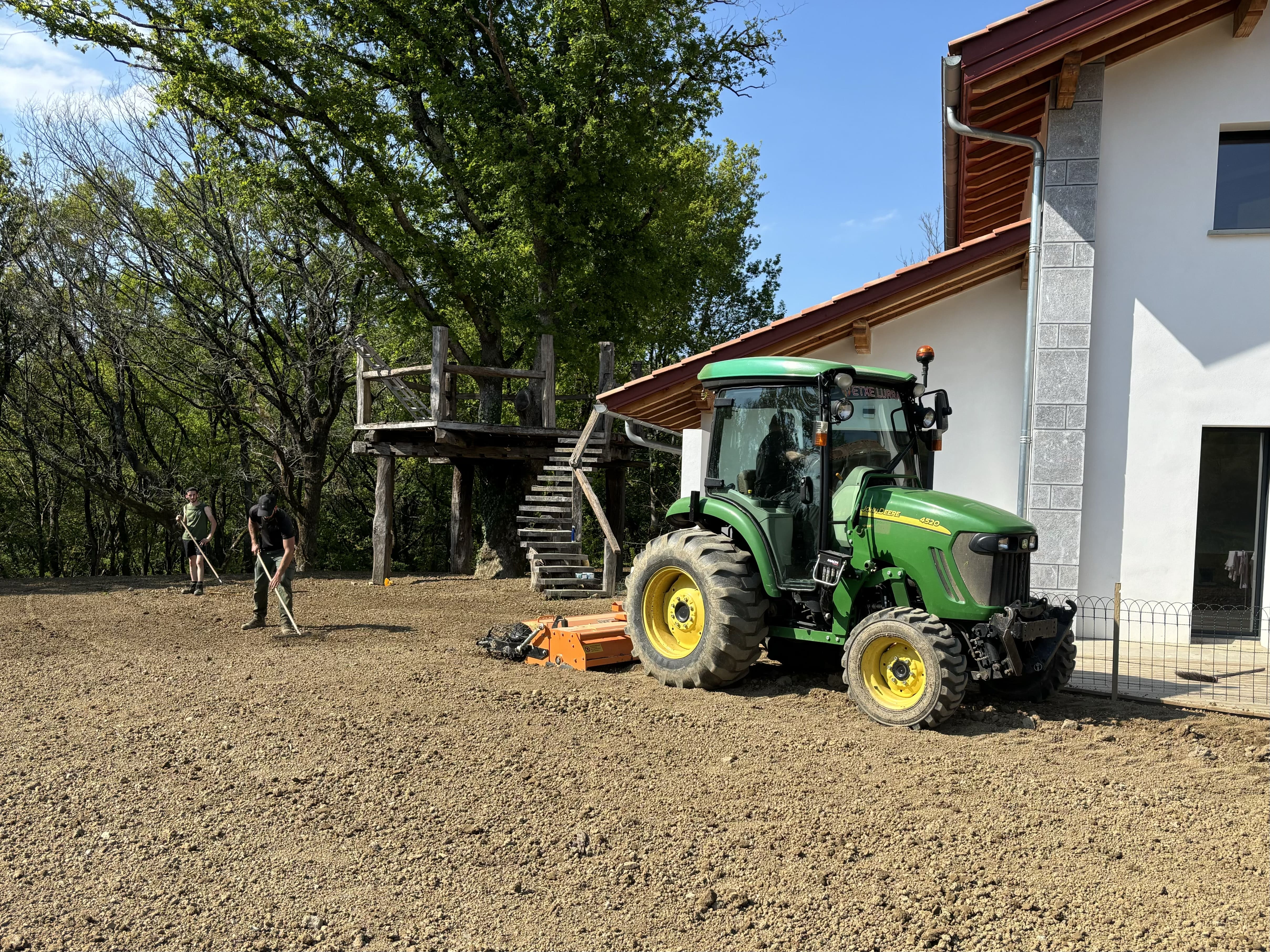 Réengazonnement d’un jardin autour d’une maison au Pays basque, avec une nouvelle pelouse fraîchement semée.